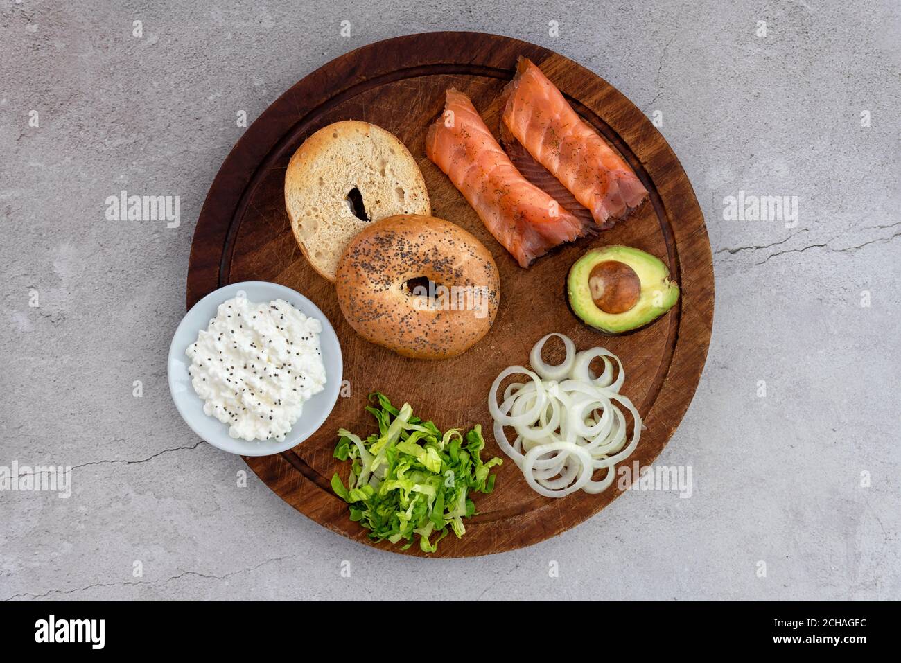 Bagel di salmone con ingredienti disposti su un tavolo di legno Foto Stock