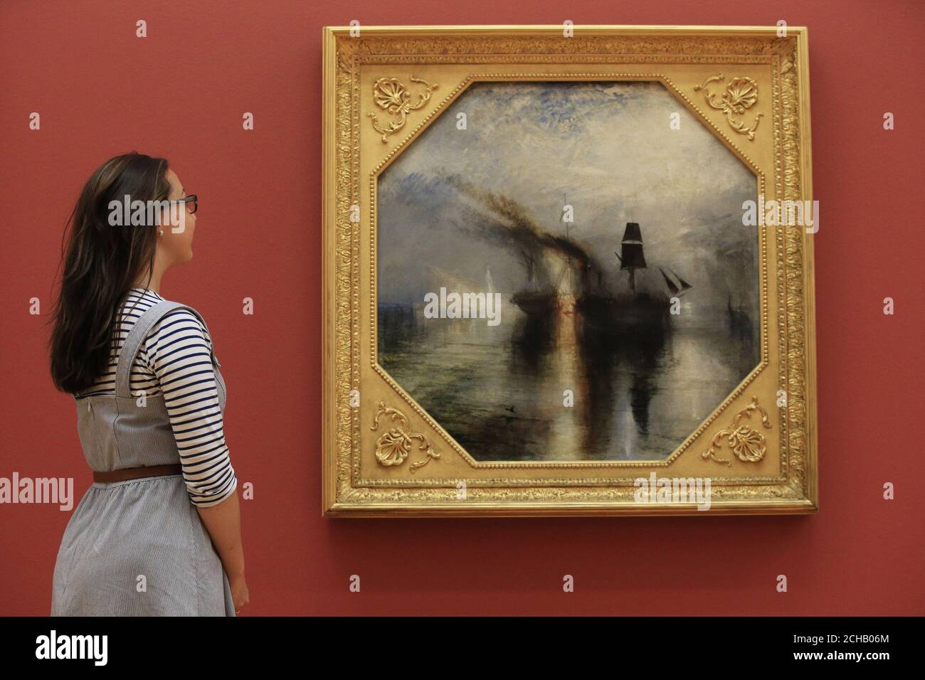 Una donna guarda al lavoro di JMW Turner Pace - sepoltura a Sea, uno dei dipinti che sono tornati a Tate Britain a Londra dopo un importante tour internazionale. Foto Stock