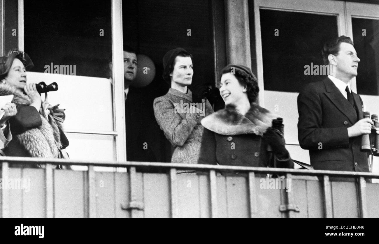 La regina Elisabetta II si gira per ridere alla regina Elisabetta, la regina madre, mentre guardano il 1955 Grand National all'Ippodromo di Aintree. Il partito reale guardò la corsa dal box di Lord Derby (r). Sullo sfondo è Lady Derby. Foto Stock