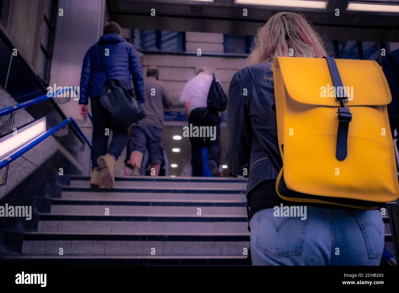 I pendolari londinesi saliscono le scale alla stazione della metropolitana Foto Stock