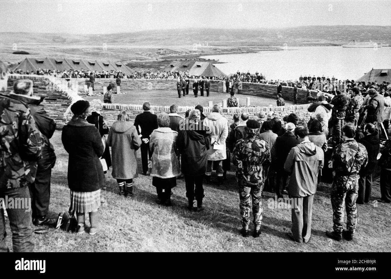 Una cerimonia al cimitero di San Carlos, con San Carlos Water (Bomb Alley) sullo sfondo. I parenti dei morti della guerra delle Falklands visitano per la prima volta le isole remote per vedere le tombe dei loro cari. Foto Stock