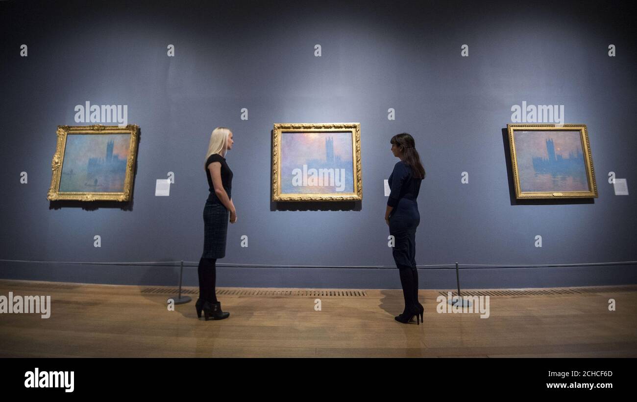 I membri del personale guardano i dipinti delle Camere del Parlamento di Claude Monet durante una fotocellula per la mostra EY: Impressionisti a Londra, Artisti francesi in esilio (1870-1904) che uniranno il maggior numero di Monet's Houses of Parliament Series visto nel Regno Unito per oltre quarant'anni al Tate Britain, Londra. Foto Stock