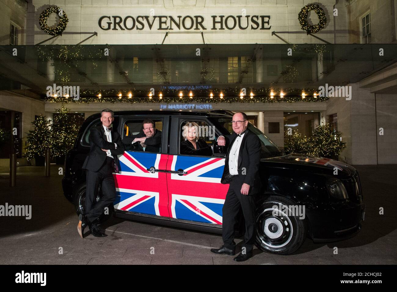 Mike Hawes, CEO di SMMT, Tony Walker, presidente di SMMT, comico Jennifer Saunders e Chris Gubbey, CEO di London EV Company arrivano alla Society of Motor Manufacturers and Traders (SMMT) cena annuale per celebrare l'industria automobilistica al Grosvenor House Hotel, Londra. Foto Stock