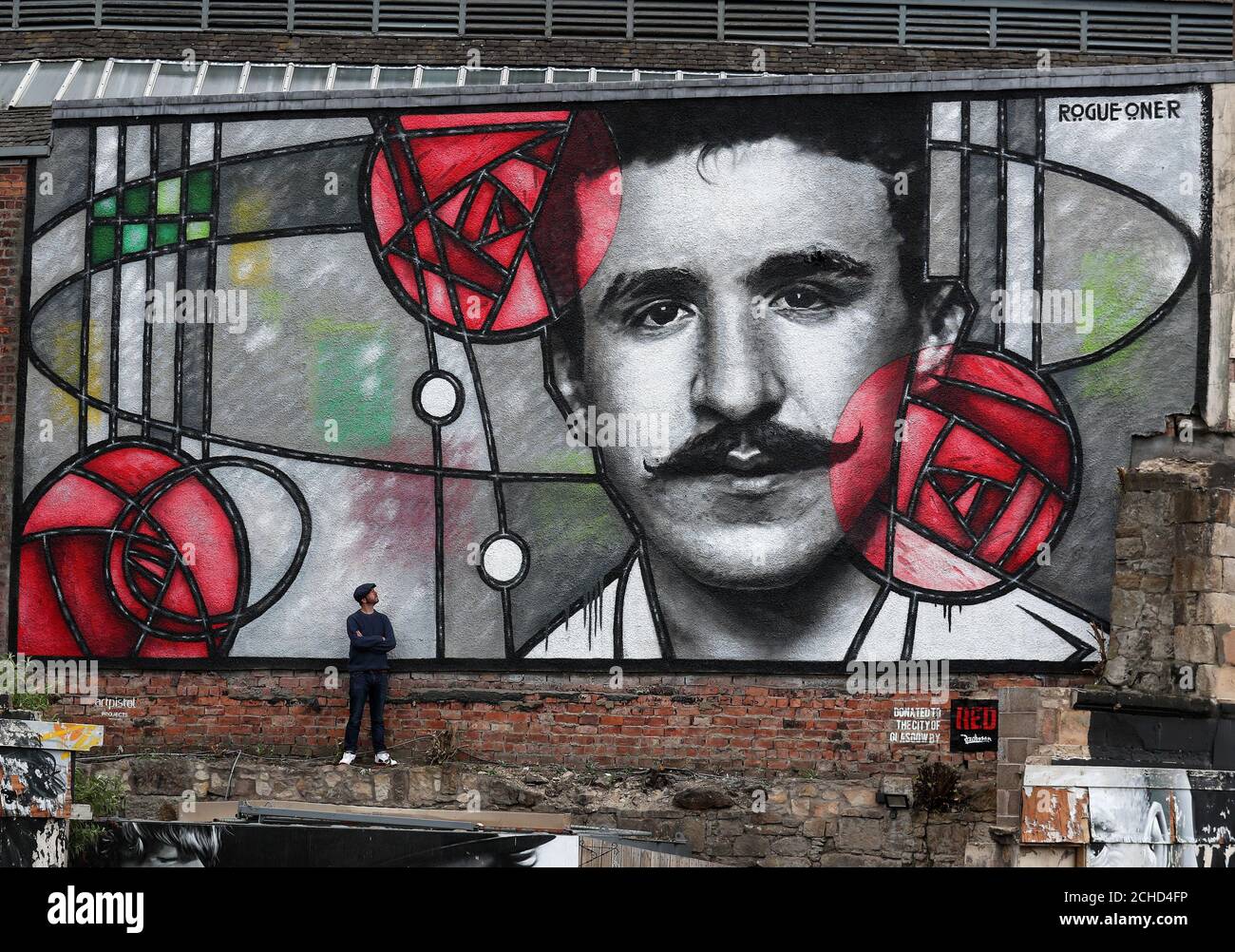 Artista Bobby McNamara noto come Rogue-uno vede il suo lavoro più recente, un gigante di arte di strada murale dedicata a Charles Rennie Mackintosh dipinta su un muro di grandi dimensioni che si affaccia sulla barra Clutha in Glasgow. Foto Stock