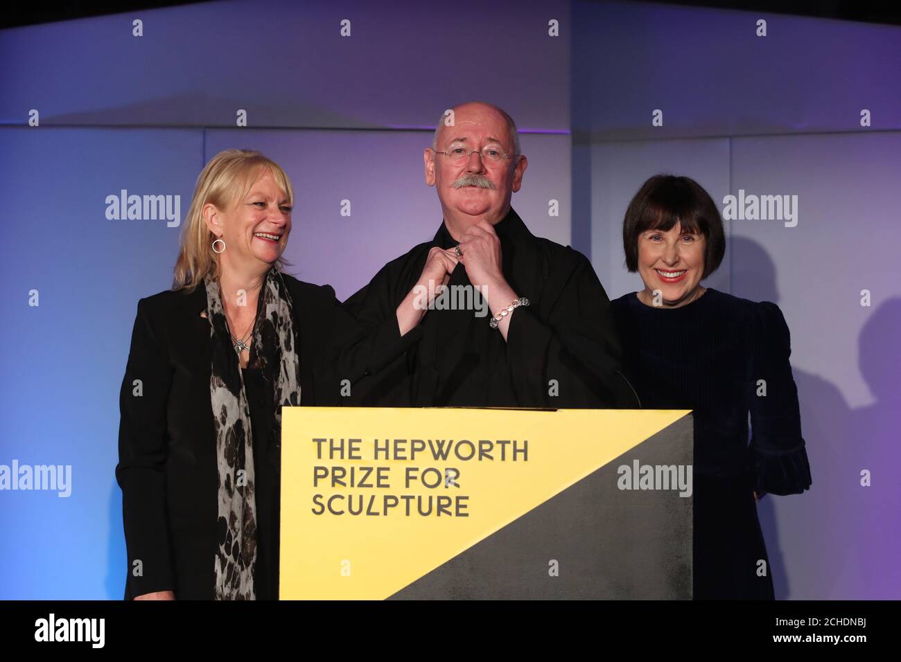 L'artista concettuale Cerith Wyn Evans (centro) riceve il premio Hepworth per la scultura, accompagnato sul palco da Louisa Buck (a sinistra) e Alice Rawsthorn durante una cerimonia alla galleria Hepworth Wakefield in West Yorkshire. Foto Stock