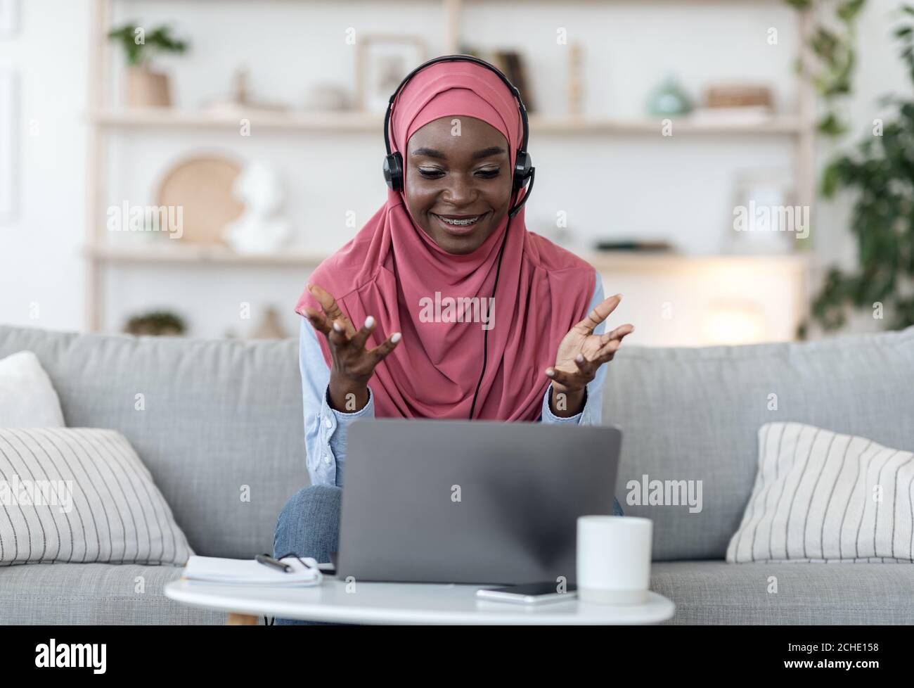 Videoconferenza. Donna musulmana nera che ha una chiamata di fotoricettore sul laptop a casa Foto Stock