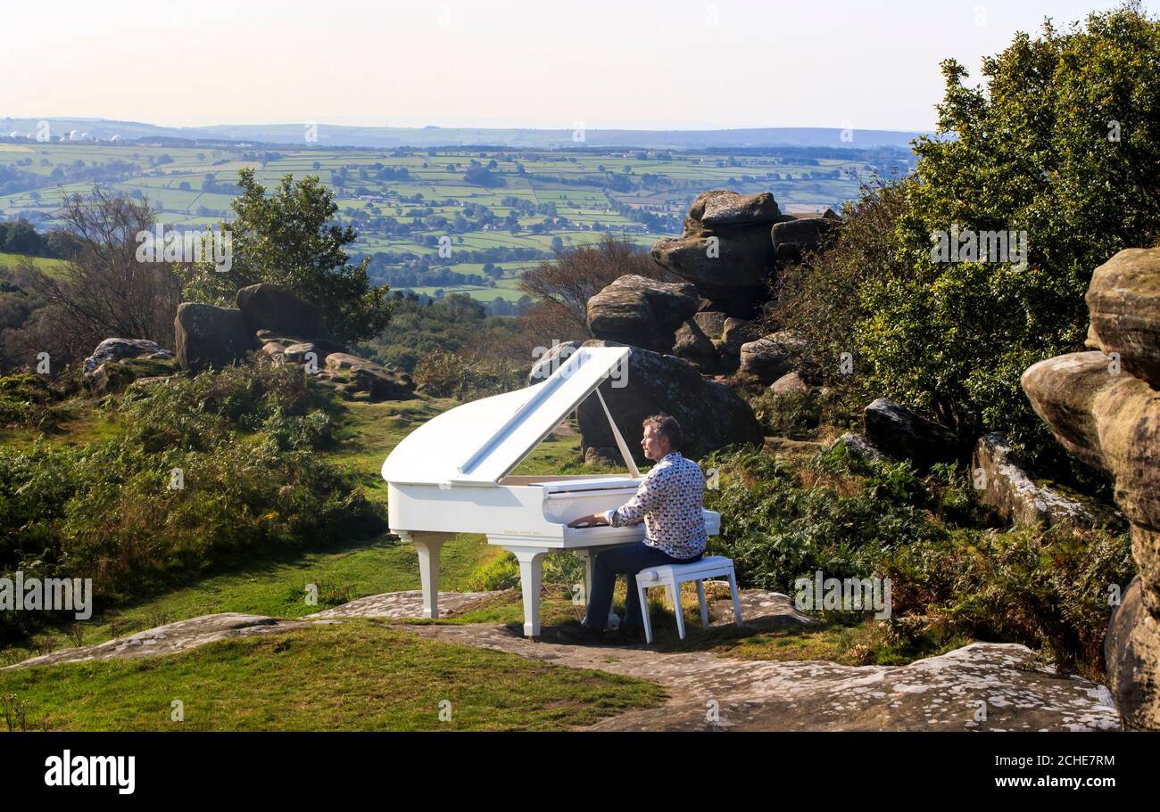 Kevin James gioca un Grand piano collocato su Brimham Rocks nella zona di Nidderdale di straordinaria bellezza naturale per evidenziare l'importanza della natura e il suo profondo impatto sulle arti Foto Stock