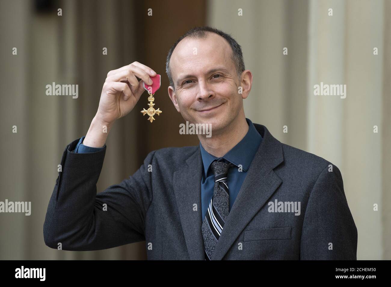 Economista e giornalista Tim Harford con la sua OBE dopo una cerimonia di investitura a Buckingham Palace, Londra. Foto Stock