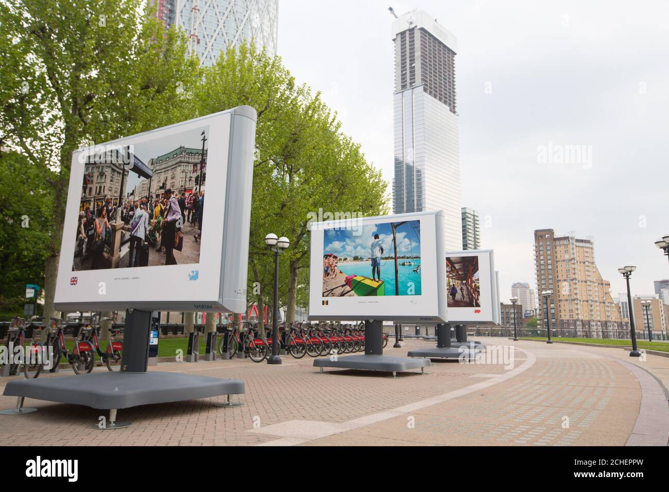 I membri del pubblico guardano le immagini delle capitali di tutto il mondo dal fotografo Jeroen Swolfs al debutto britannico della mostra fotografica Streets of the World a Canary Wharf, Londra. Foto Stock