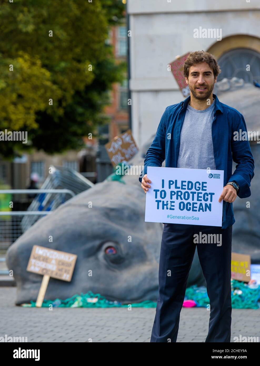 SOLO PER USO EDITORIALE Mathieu Flamini, calciatore professionista e imprenditore ambientale guarda come attivisti del gruppo di azione ambientale, I Surfers Against Sewage portano al Parlamento una creatura marina di 15 piedi Ôunknown per chiedere ai deputati di firmare la promessa #GenerationSea di proteggere l'oceano dall'inquinamento plastico e dalla crisi climatica in occasione della Giornata mondiale dell'ambiente di Londra. Foto Stock