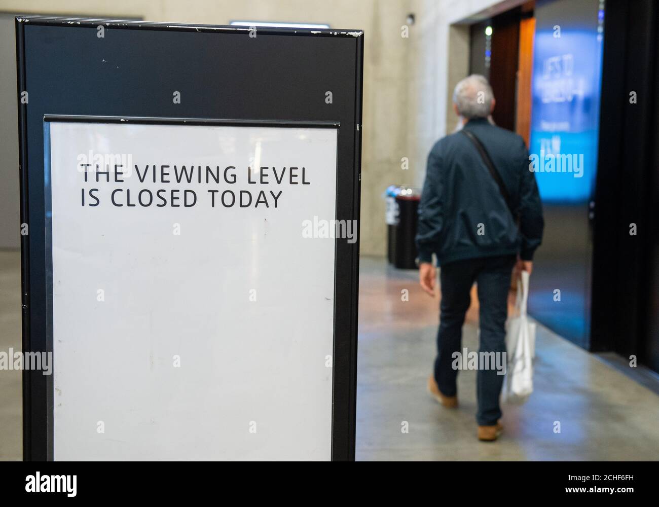Un membro del pubblico passa accanto a un cartello chiuso nella galleria d'arte Tate Modern di Londra, dopo l'arresto di un maschio di 17 anni sospettato di tentato omicidio dopo che un ragazzo di sei anni è stato gettato dalla piattaforma di osservazione al decimo piano di domenica. Foto Stock