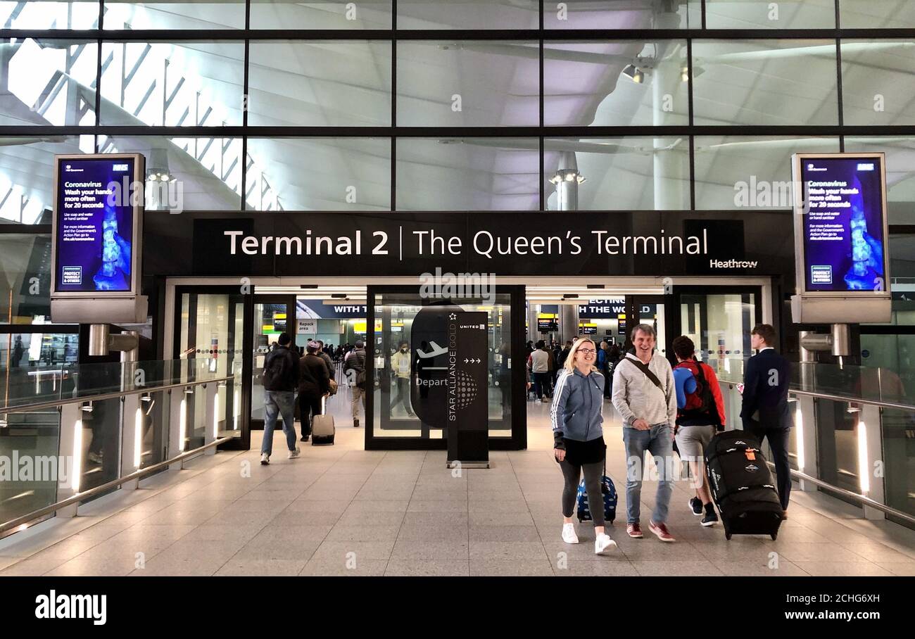 Gli avvertimenti del governo su Coronavirus all'ingresso del Terminal 2 dell'aeroporto di Londra Heathrow il giorno dopo che il primo ministro ha detto che Covid-19 'è la peggiore crisi di salute pubblica per una generazione', e il top scienziato del governo ha avvertito che fino a 10,000 persone nel Regno Unito sono già infettate. Foto Stock