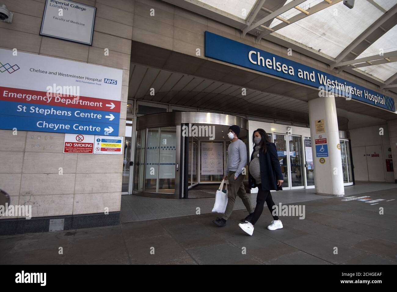 Una coppia indossa maschere al di fuori del Chelsea e Westminster Hospital di Londra mentre il Regno Unito continua a bloccare per aiutare a frenare la diffusione del coronavirus. Foto Stock