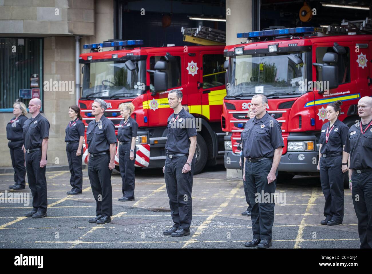 Il personale della stazione e dell'orologio verde della Tollcross Community Fire Station di Edimburgo osserva un minuto di silenzio in memoria dei colleghi che hanno perso la vita nel campo di attività. Foto Stock