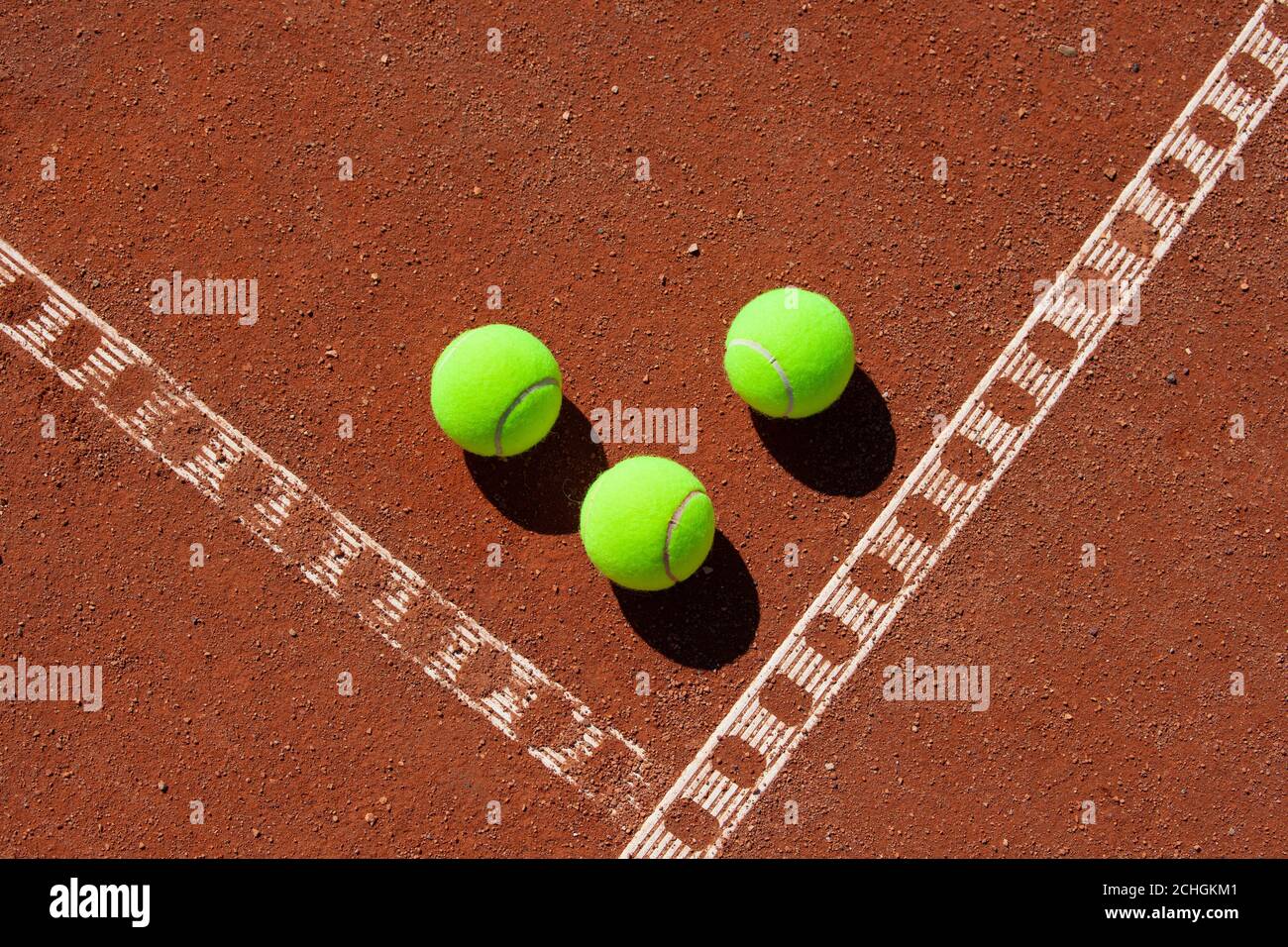 Tre palle da tennis nell'angolo di un campo di argilla Foto Stock