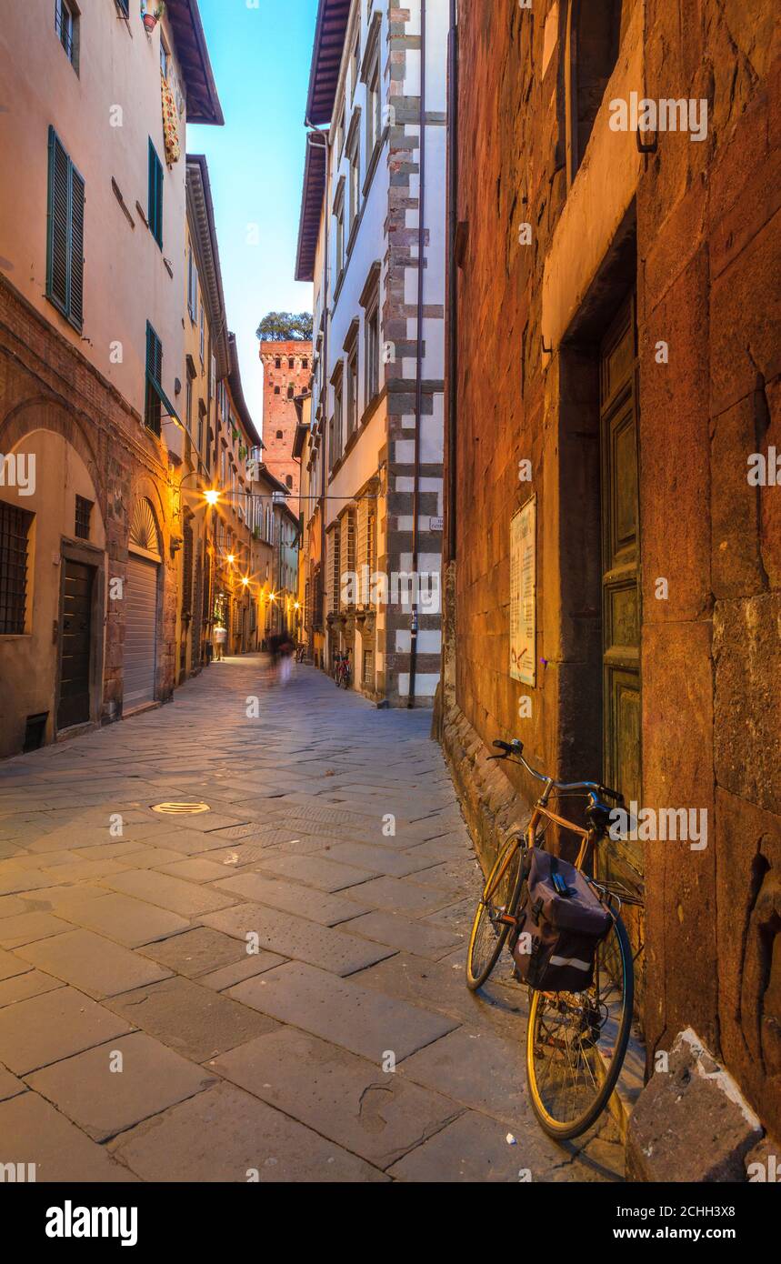 Una strada nel centro storico di Lucca, con vista sulla Torre Guinigi Foto Stock