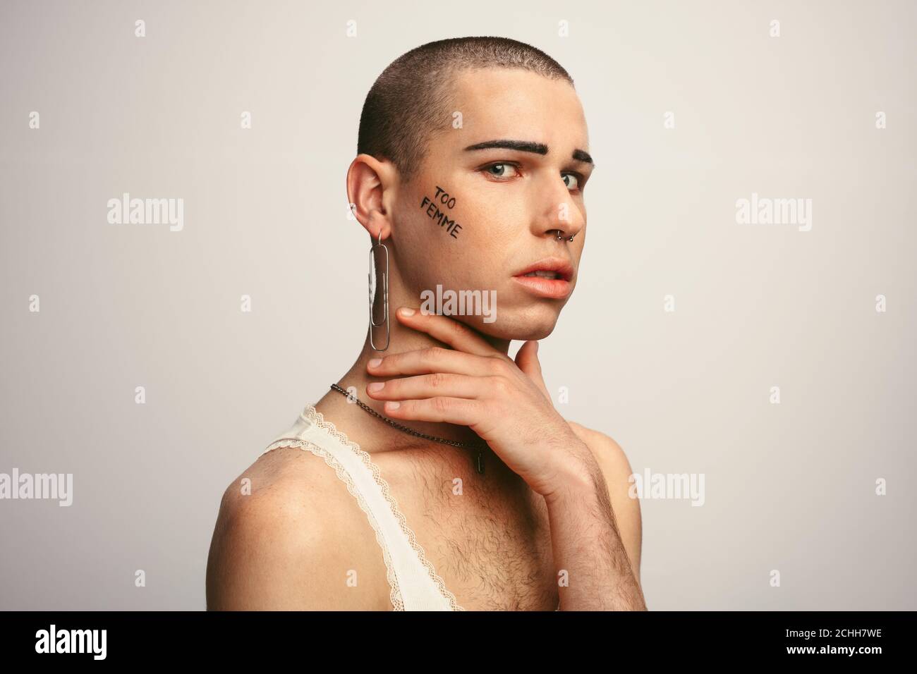 Croce vestito uomo con troppo femme scritto sul viso guardare la fotocamera con espressioni serie Foto Stock