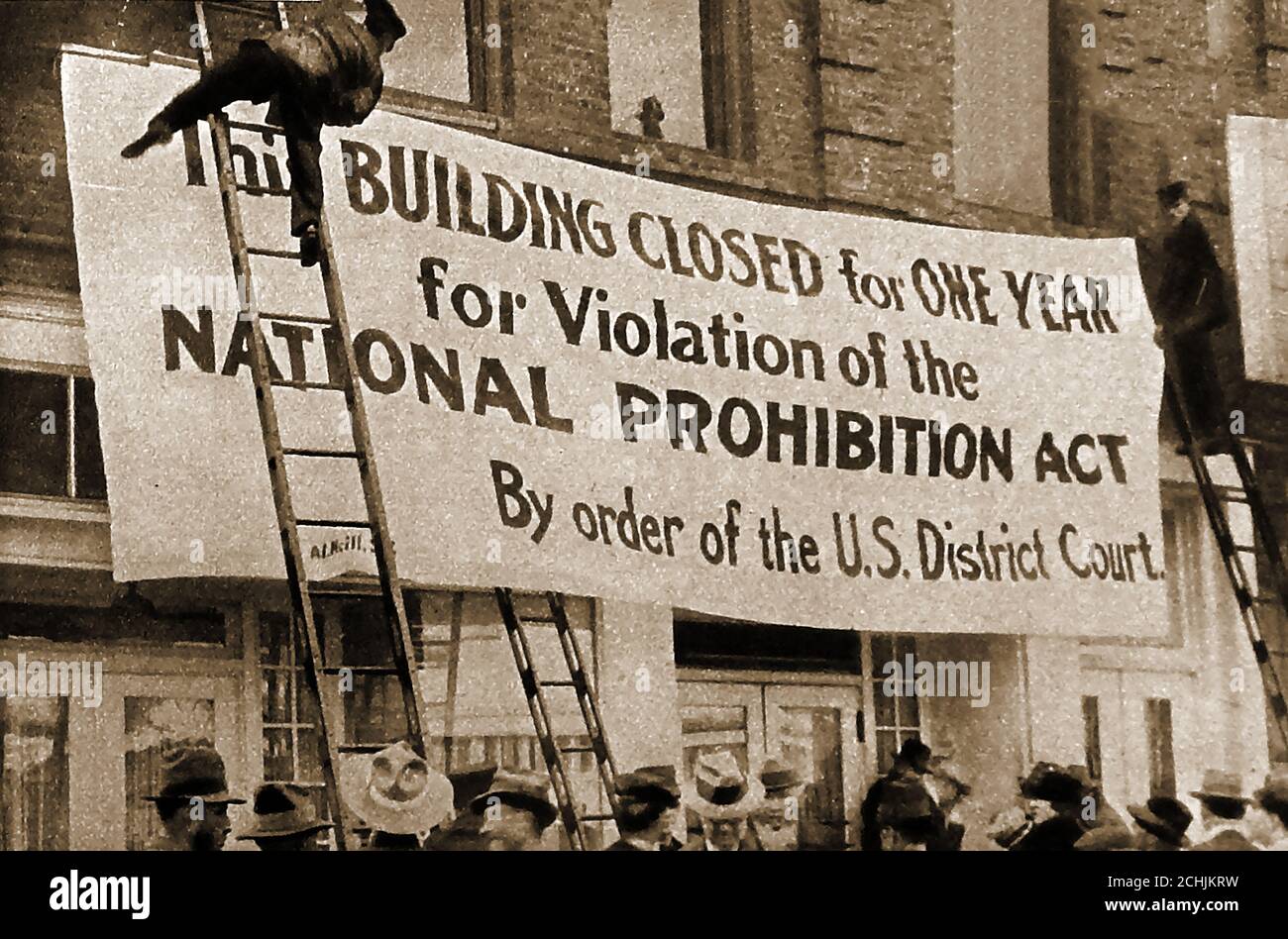 1922 divieto americano - una vecchia fotografia che mostra le autorità aggancia un poster che consiglia un edificio è in fase di chiusura per violazione del National Proibizional Act. Il divieto negli Stati Uniti costituiva un divieto virtuale a livello nazionale per la produzione, l'importazione, il trasporto e la vendita di bevande alcoliche. Durò dal 1920 al 1933. Foto Stock