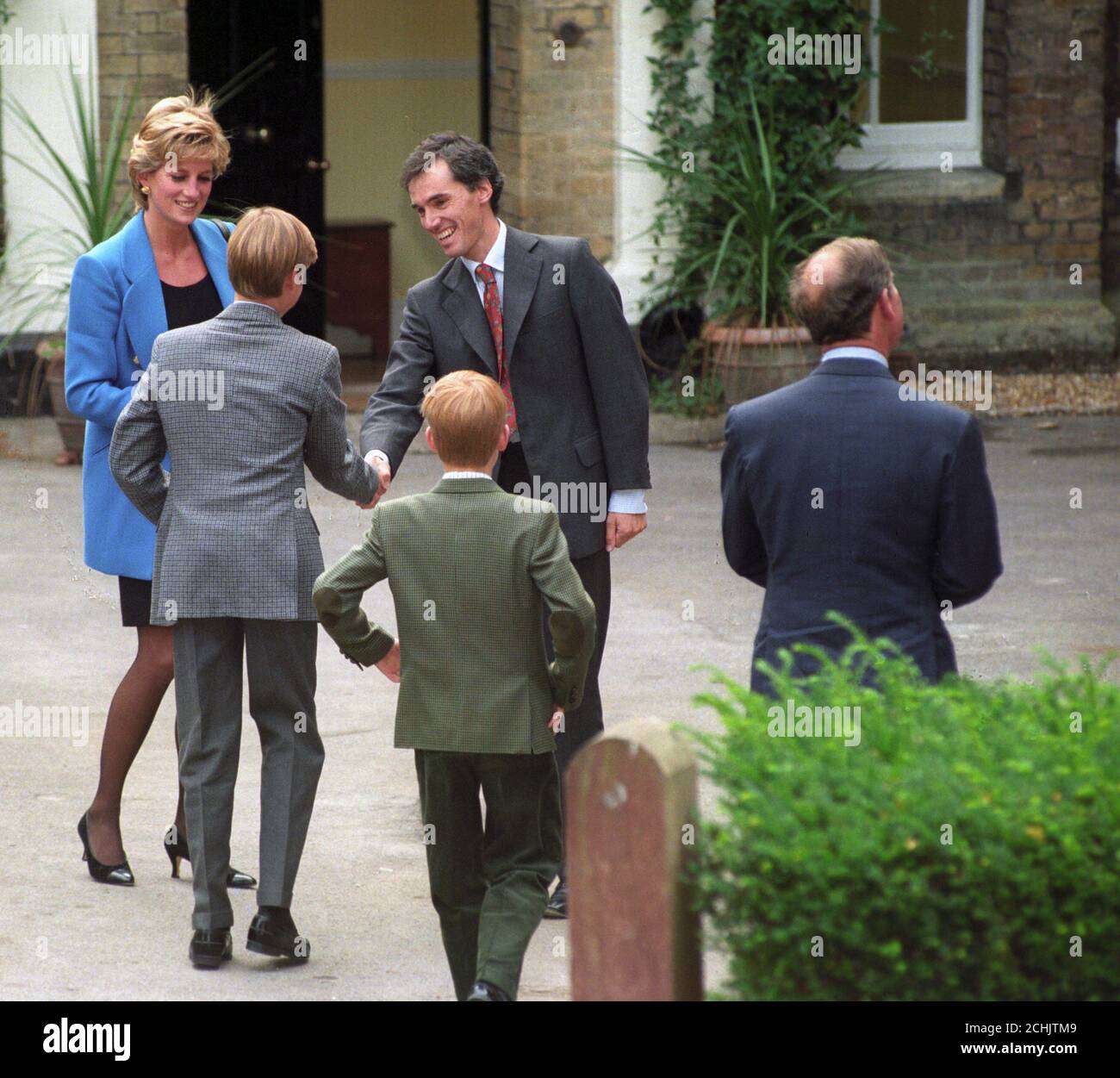 Il Principe e la Principessa di Galles e i loro figli il Principe William (l) e il fratello minore il Principe Harry vengono accolti dal Maestro di Casa, il Dr Andrew Gailey, quando arrivano alla Manor House per il primo giorno di William a Eton. Foto Stock