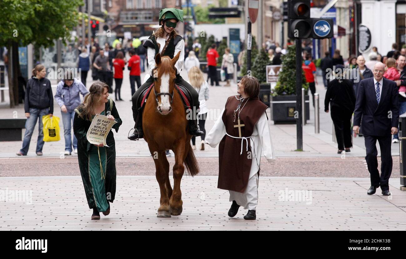 Sara Cowan Reynolds, attivista della lotta alla povertà di Oxfam, si vestì mentre Robin Hood cavalcava un cavallo lungo Buchanan Street a Glasgow, accompagnato da Kristin Reynolds vestita come Maid Marion per chiedere ai governi del G20 di sottoscrivere la Robin Hood Tax. Foto Stock