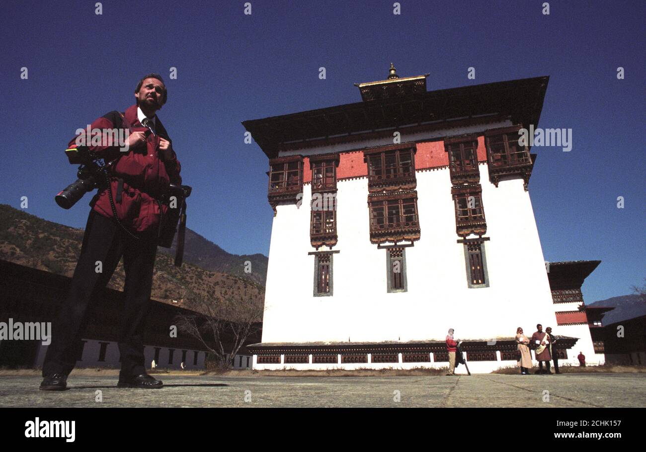 IL FOTOGRAFO JOHN STILLWELL DEL PERSONALE DEL PA FA UNA PAUSA MENTRE COPRE LA VISITA DEL PRINCIPE DEL GALLES A PARO, BHUTAN. Foto Stock