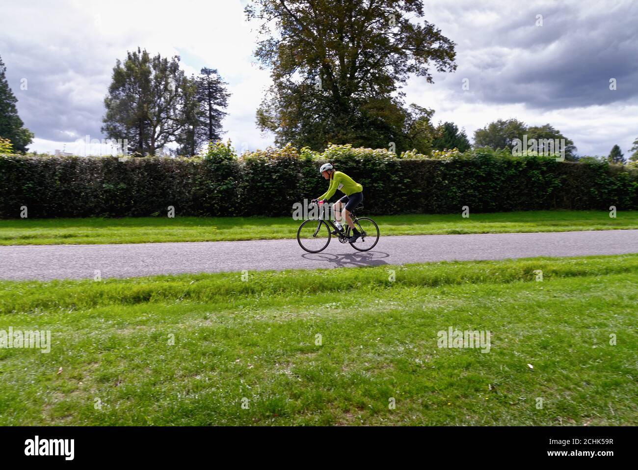Un ciclista maschile di mezza età che corre su una strada di campagna Nelle colline di Surrey vicino Dorking Surrey Inghilterra UK Foto Stock