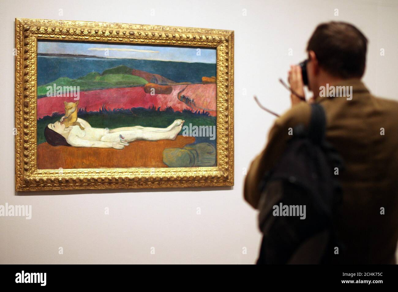 Un uomo guarda The Loss of verginity, 1890-1891 alla mostra Gauguin: Maker of Myth al Tate Modern di Londra. Foto Stock