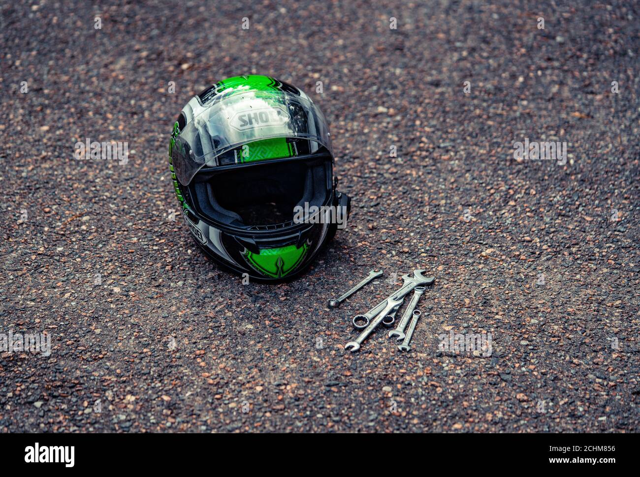 casco da moto a terra e alcuni attrezzi vicino ad esso Foto stock - Alamy