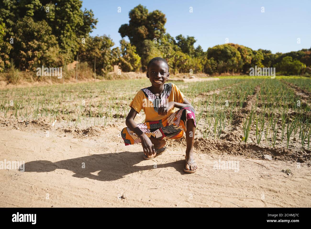 African Black Boy si trova davanti al campo agricolo di Bamako, Mali Foto Stock