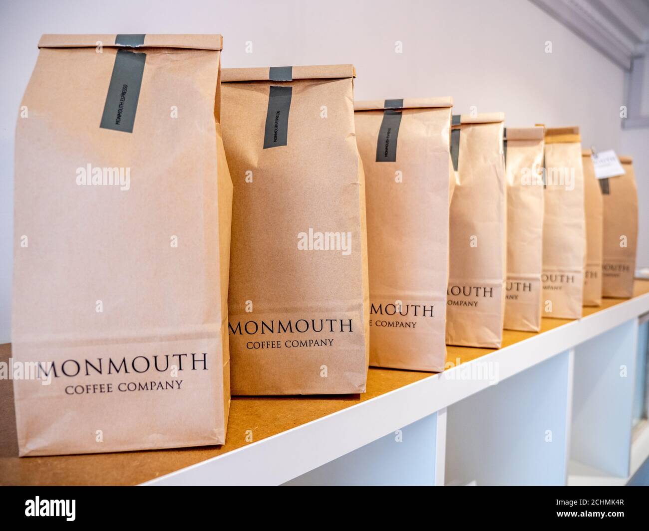 Monmouth Coffee Company. Una fila di chicchi di caffè in sacchetto con il marchio dell'azienda artigianale di caffè londinese. Foto Stock