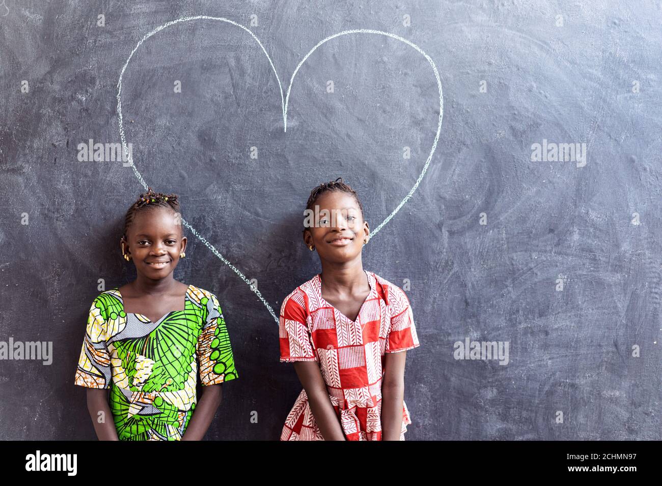 Due belle cute African Black Girls in piedi davanti Lavagna con simbolo di  amore del cuore grande Foto stock - Alamy