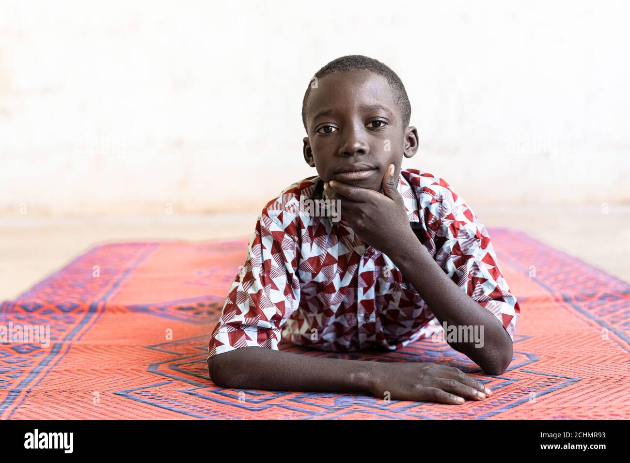Black African Ethnicity Boy in posa come un modello sdraiato Su mat Foto Stock