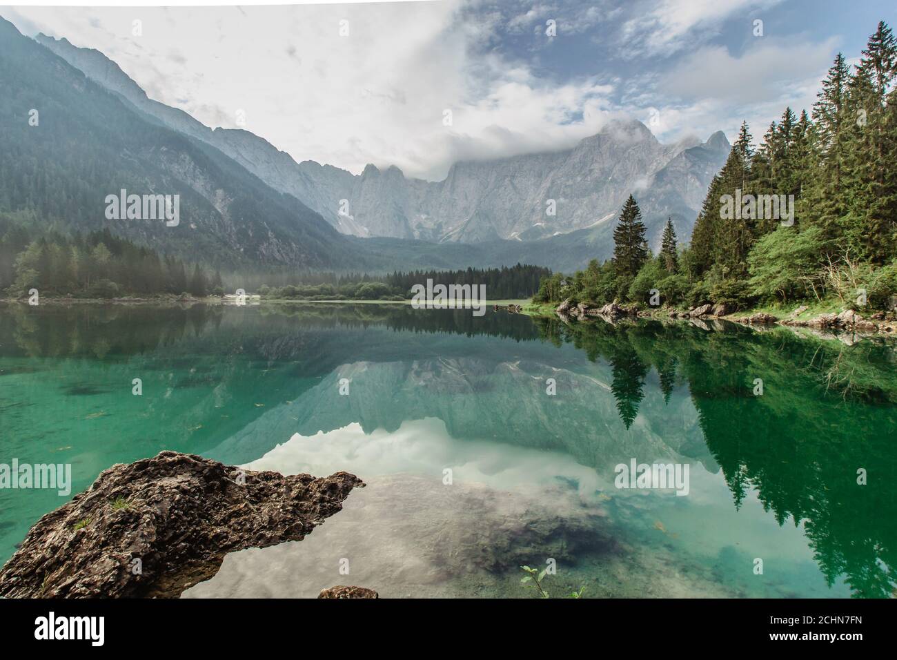 Riflessione specchio in Lago di Fusine, Italia. Estate primavera colori e Mangart montagna sullo sfondo all'alba in Italien Alps.Beautiful tranquillo Foto Stock