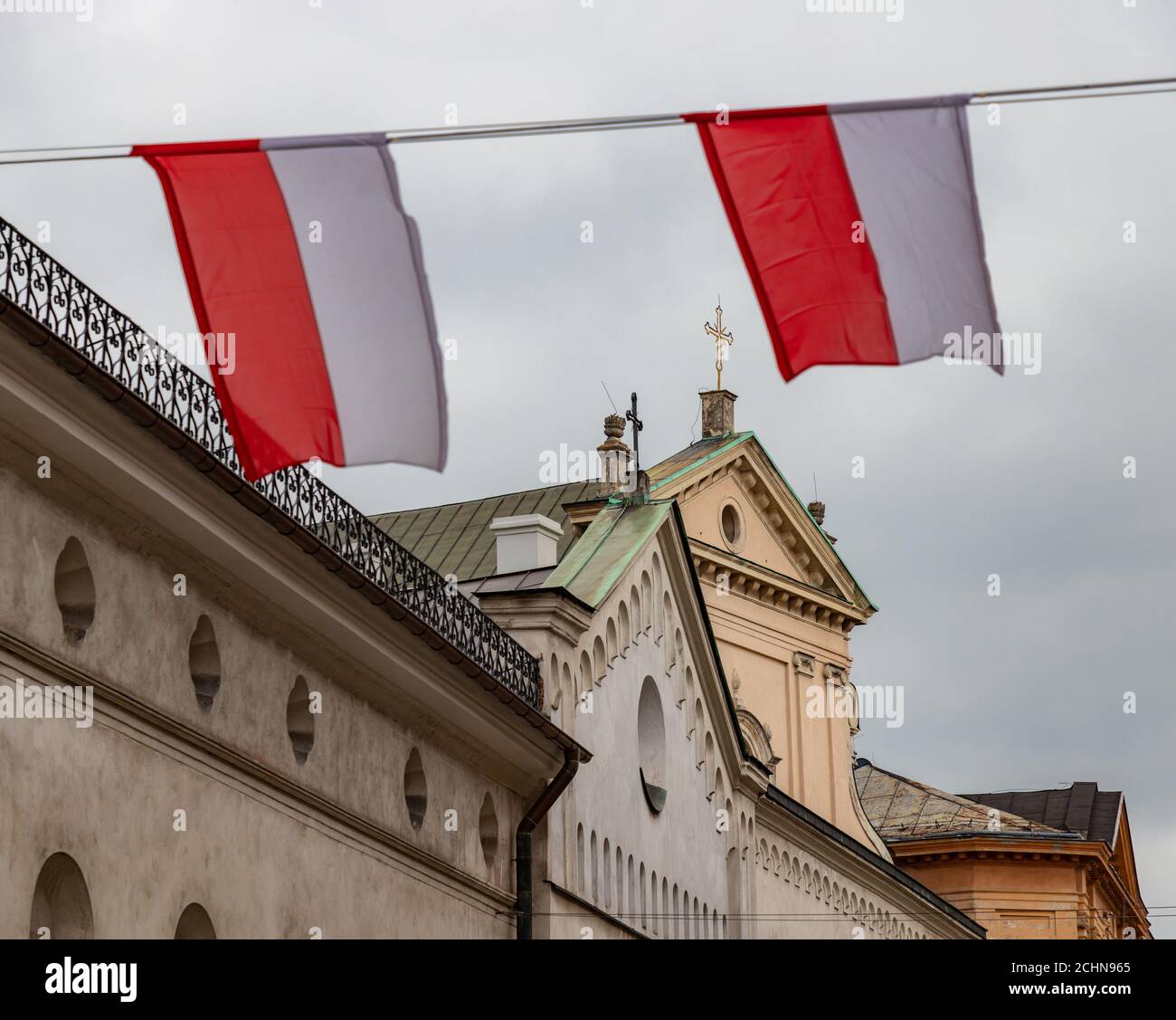 Una foto di due bandiere polacche che sventolano in una strada (Cracovia). Foto Stock