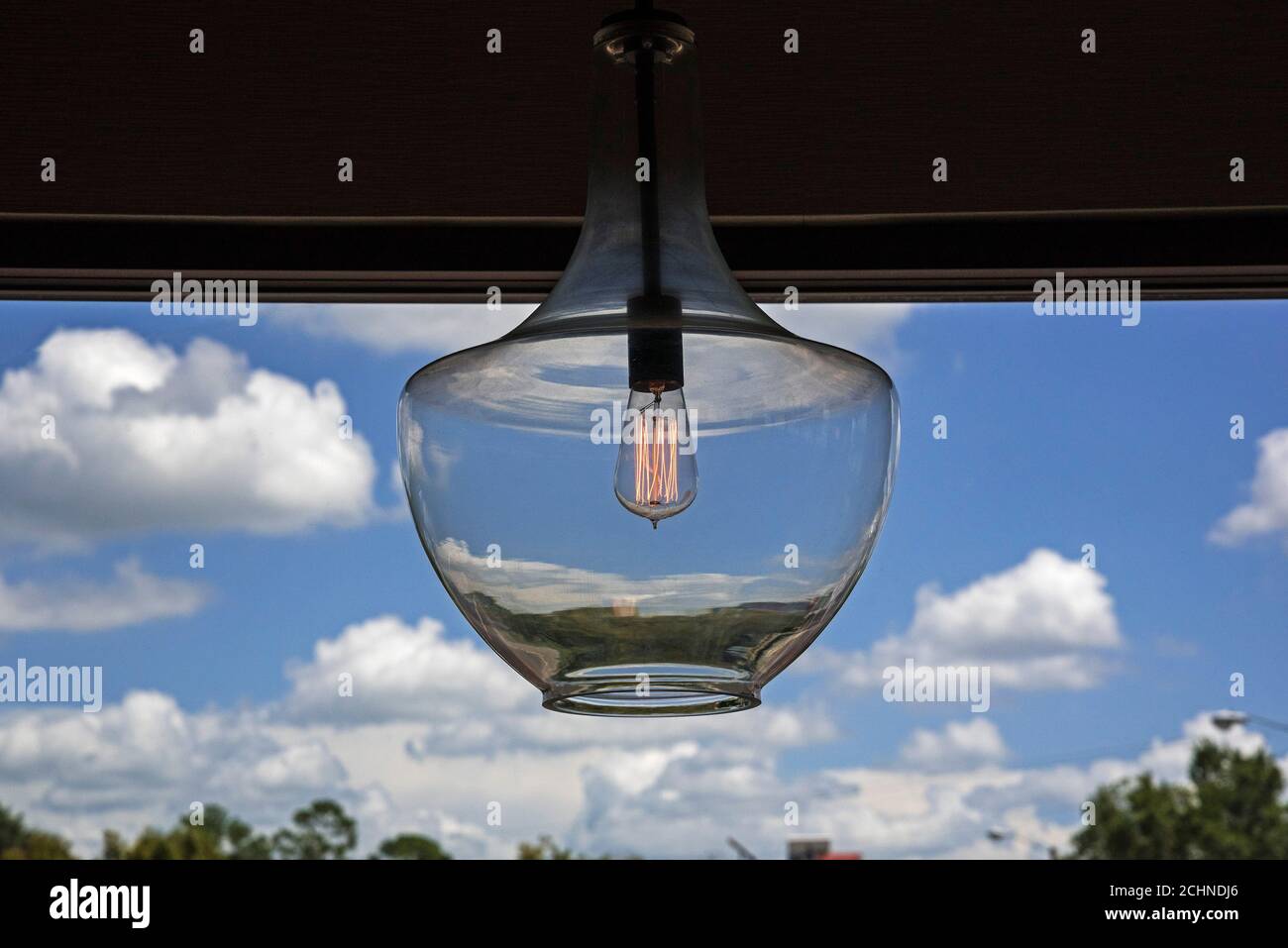 La lampadina a filamento ispirata a Thomas Edison, dal look retrò, risplende in un mondo appeso in un ristorante. Foto Stock
