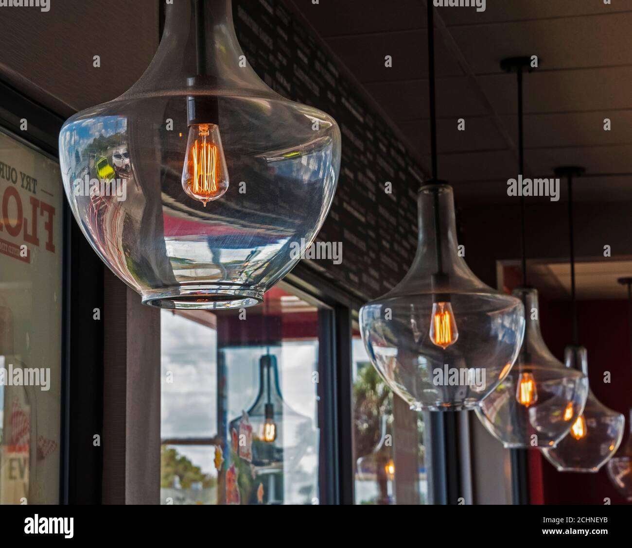 La lampadina a filamento ispirata a Thomas Edison, dal look retrò, risplende in un mondo appeso in un ristorante. Foto Stock