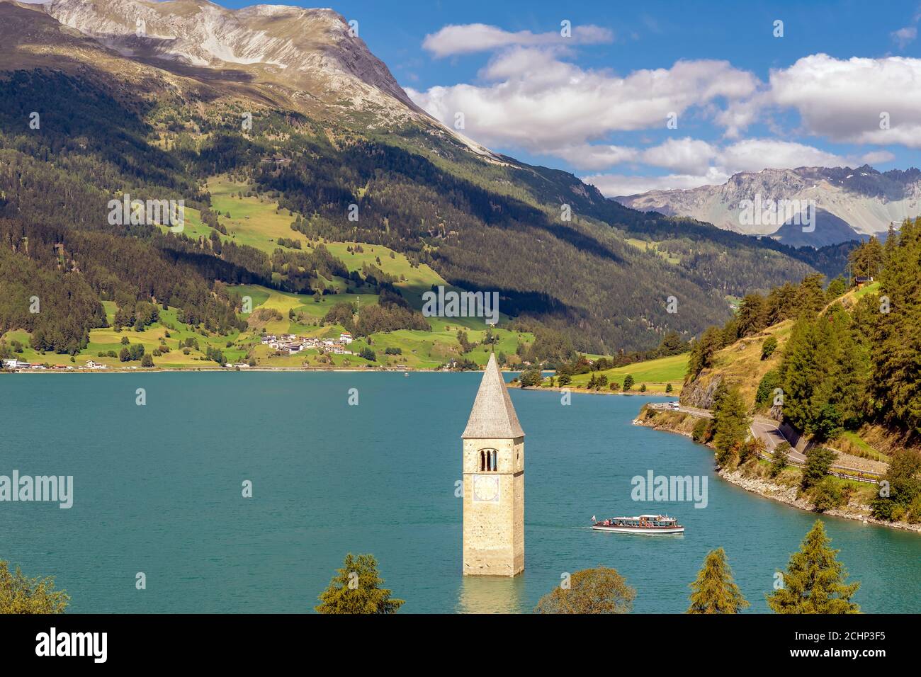 Vista dall'alto di una crociera sul Lago di Resia vicino all'antico campanile sommerso di Curon Venosta, Alto Adige, Italia Foto Stock