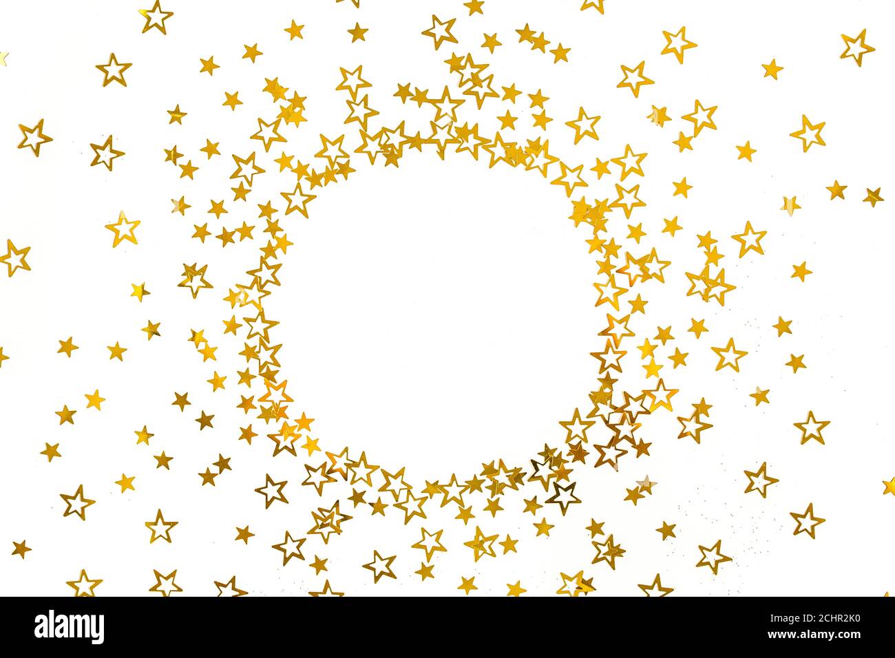Cornice rotonda con stelle d'oro confetti, decorazione con glitter su sfondo bianco e festoso. Modello di Natale o Capodanno. Disposizione piatta, vista dall'alto Foto Stock