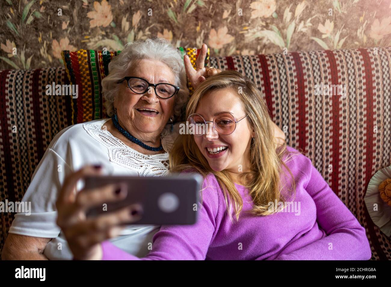 La donna anziana e la nipote adulta che utilizzano lo smartphone insieme Foto Stock