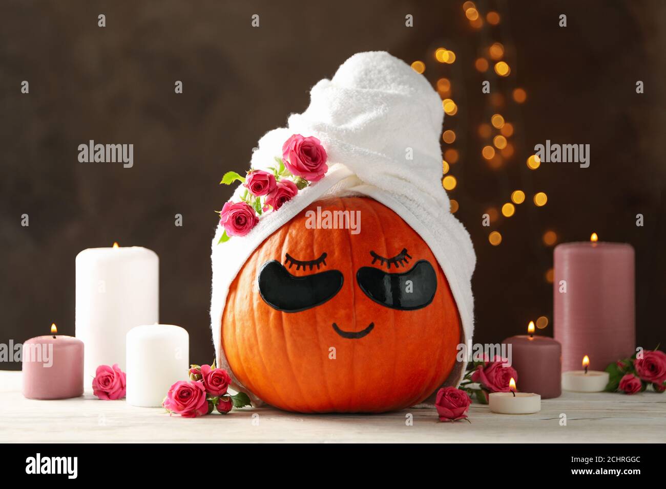 Candele e zucca con macchie sugli occhi su sfondo marrone Foto Stock