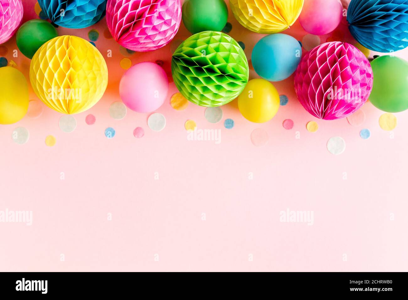 Palloncini e confetti su sfondo rosa. Compleanno, concetto di festa. Disposizione piatta, vista dall'alto. Sfondo festa di compleanno Foto Stock