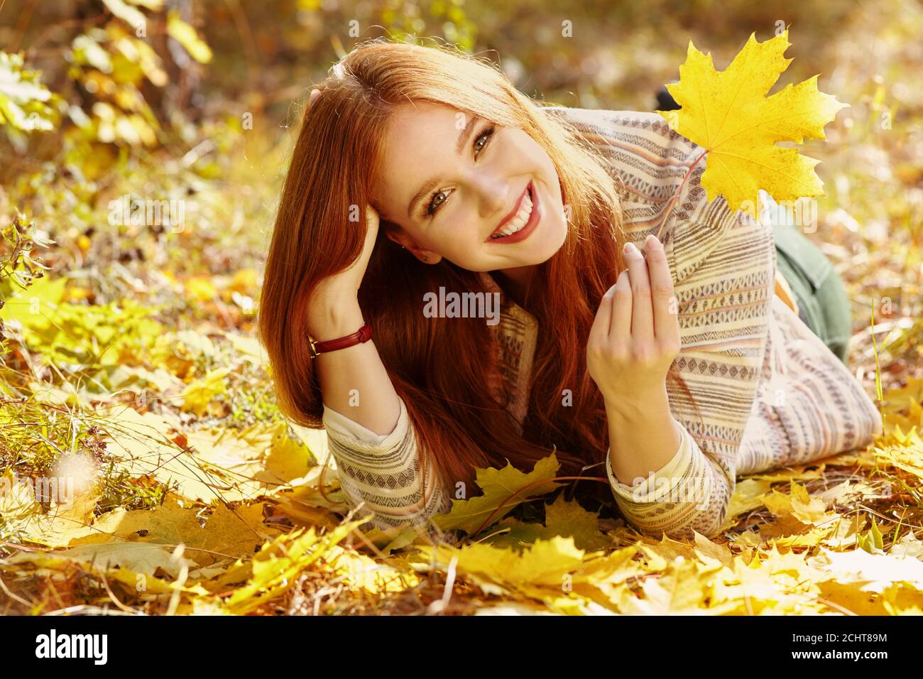 Donna di colore giallo con foglie di acero in autunno Foto Stock
