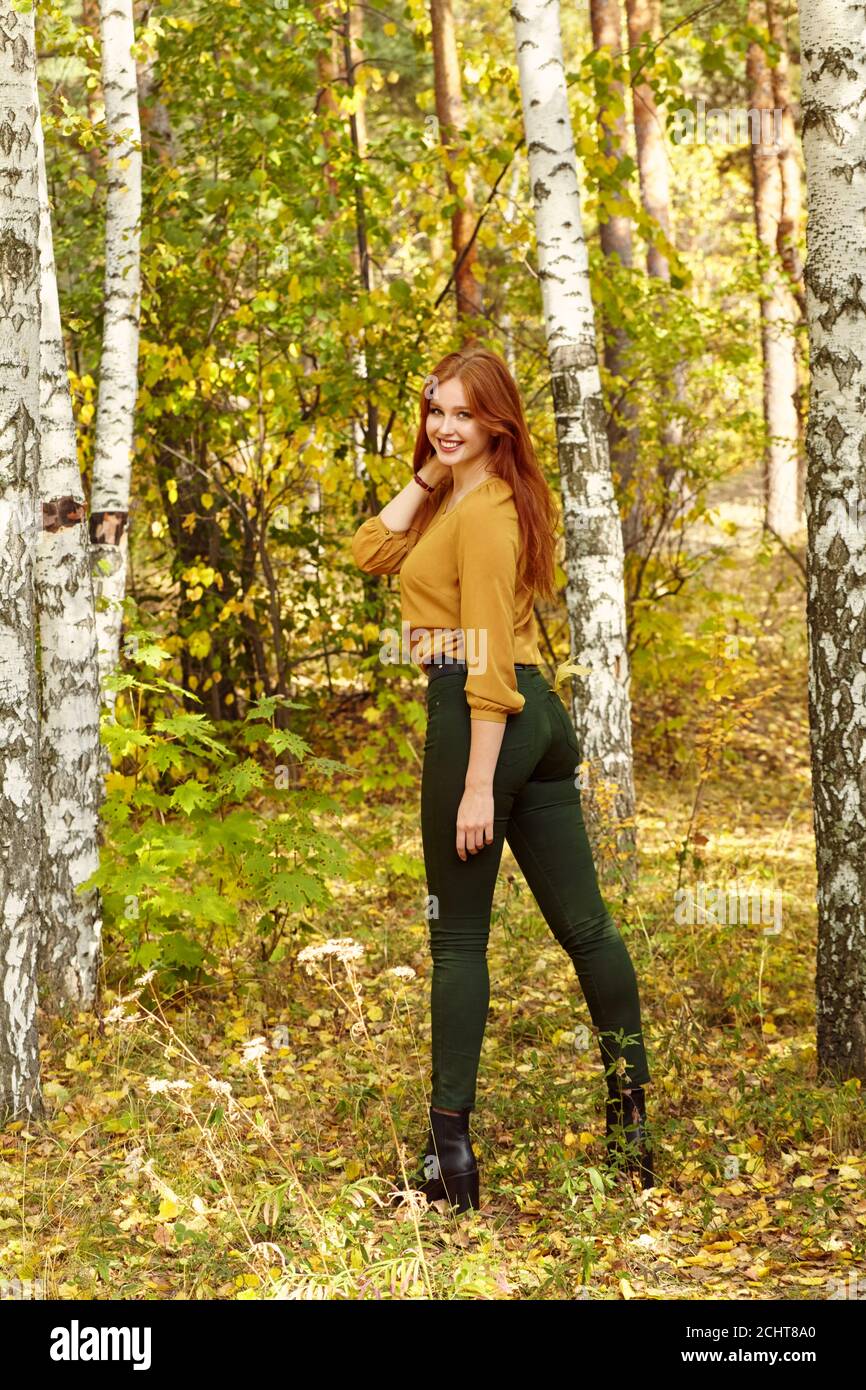 ritratto di una bella donna rossa nella foresta d'autunno Foto Stock