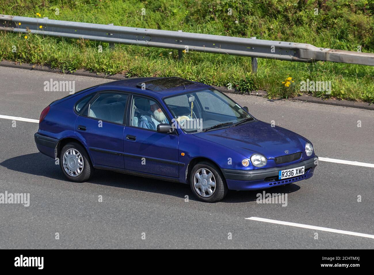 1998 anni Novanta Toyota Corolla 1.3 GS benzina berlina Vehicular traffico veicoli in movimento, auto che guidano veicoli su strade del Regno Unito, motori, motori sulla rete autostradale M6. Foto Stock