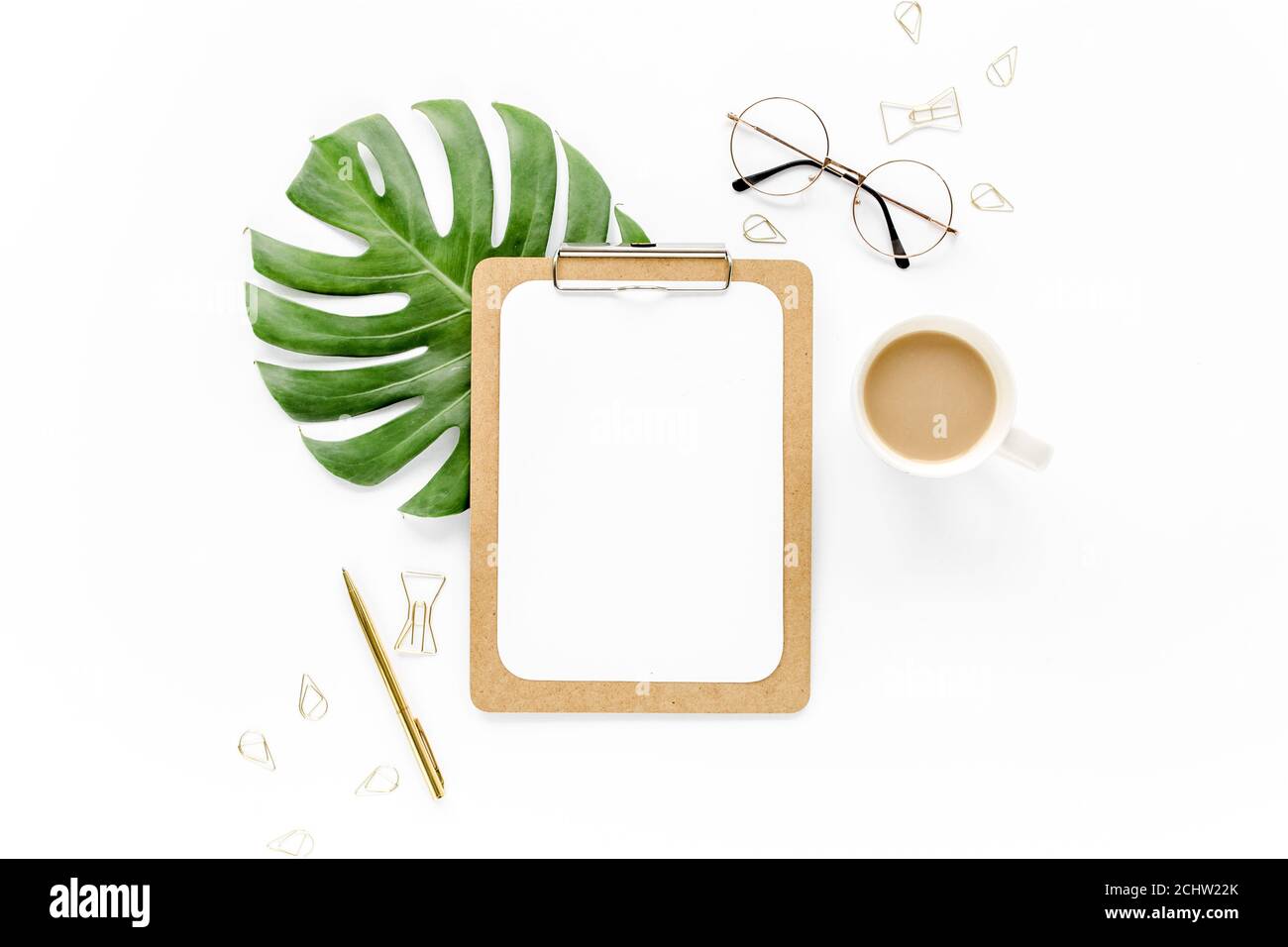 Home Office Workspace mockup con foglie tropicali Monstera, appunti, e accessori su sfondo bianco. Disposizione piatta, vista dall'alto Foto Stock