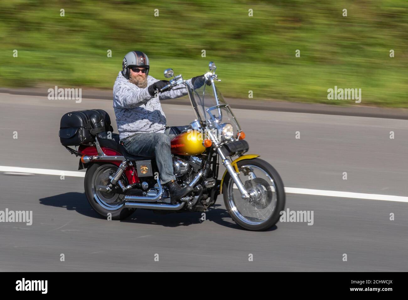 Rosso arancio Harley Davidson motociclista; due ruote di trasporto, moto, veicolo, strade, moto, motociclisti motociclisti a Chorley, Regno Unito Foto Stock