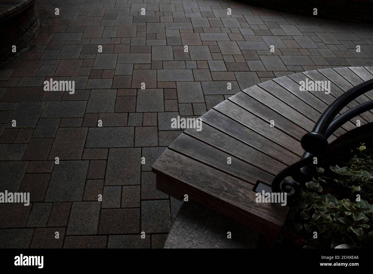 Una panca vuota in una piazza urbana Foto Stock