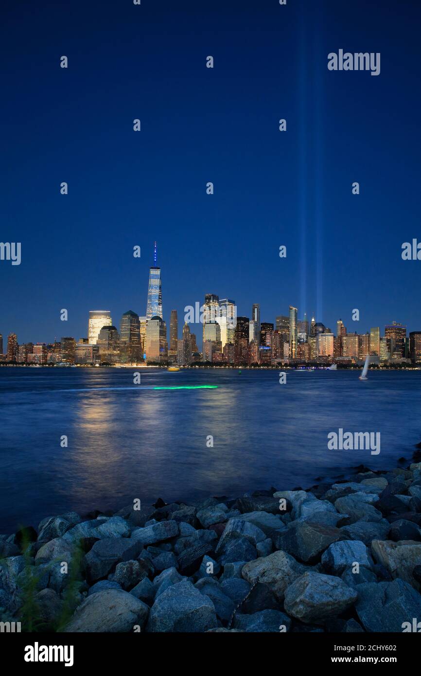 La vista notturna dello skyline di Lower Manhattan con l'anno 9/11 Luci tribute che proiettano nel cielo con il fiume Hudson in primo piano Dal Liberty state Park.New Jersey.USA Foto Stock