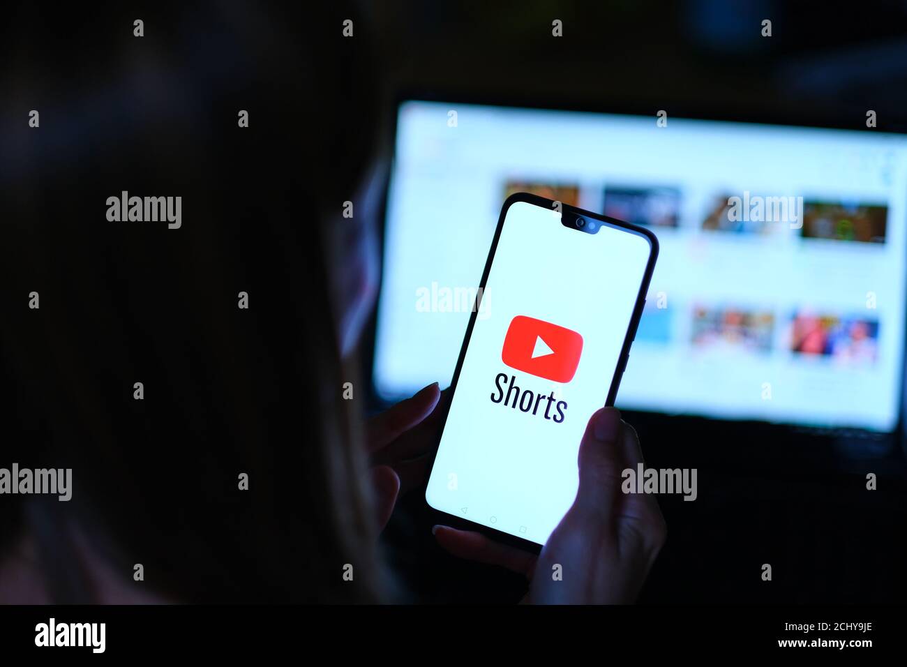 : YouTube Shorts app logo visto sullo smartphone che reggono da giovane ragazza. Si tratta di una nuova app video a ciclo breve, concorrente di TikTok, Bytes e Reels Foto Stock