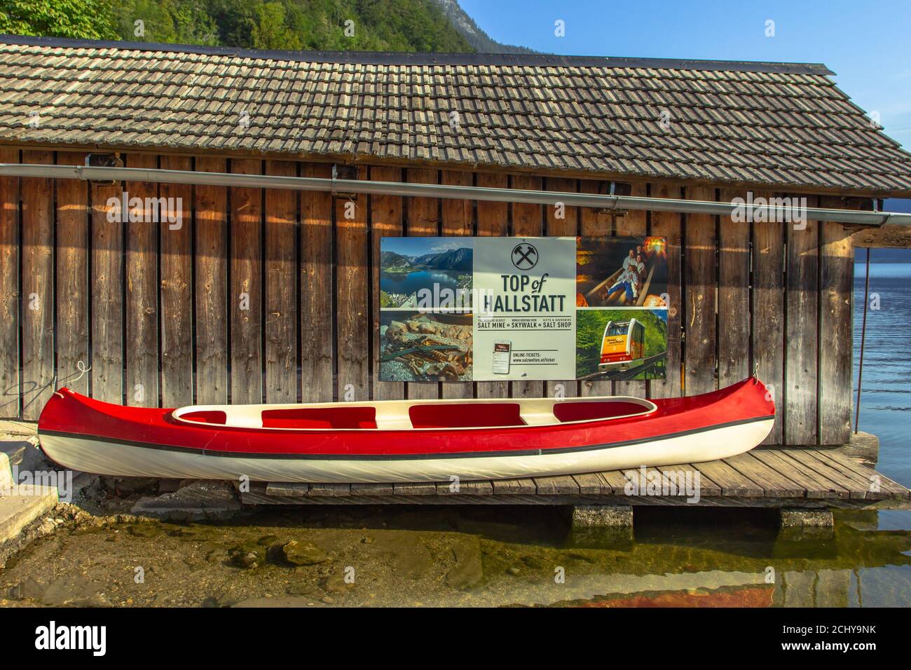 Hallstatt, Austria - 10 agosto 2020. Barca turistica rossa sulla riva di Hallstatter vedere e pubblicità per Top of Hallstatt punto di vista nel backgroun Foto Stock
